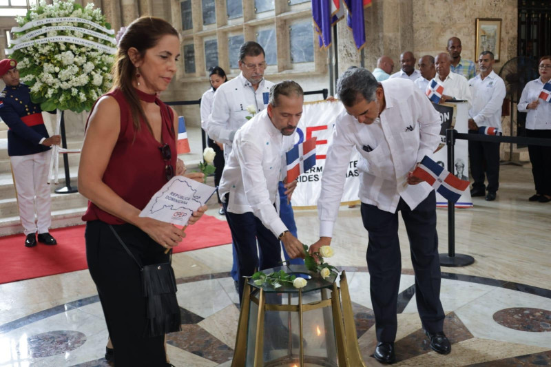 Juan Pablo Urib, presidente de Efemerides Patria junto a Ingrid Fernandez, hija del coronel Fernando Dominguez,depositan ofrenda floral y realizan el ritual en la llama votiva.