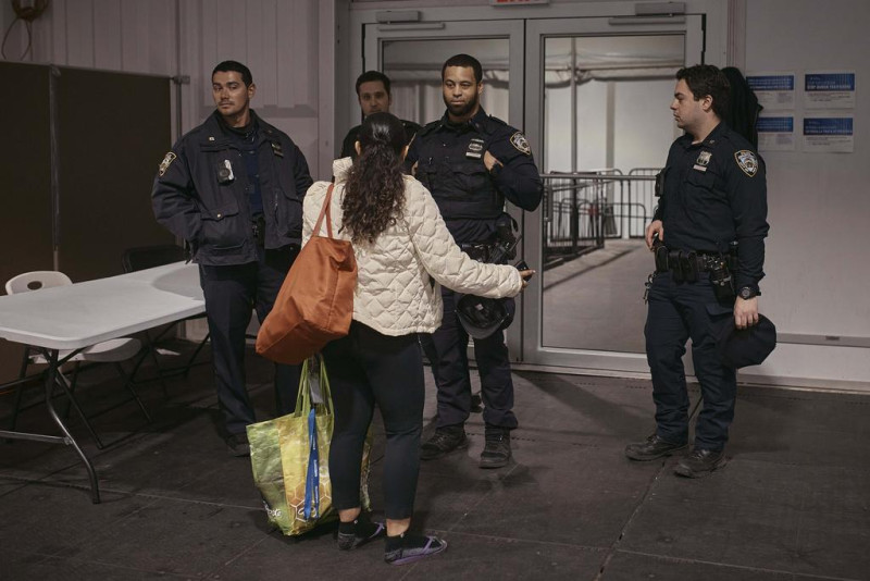 Una migrante habla con la policía en un albergue para migrantes en Randall's Island, el martes 9 de abril de 2024, en Nueva York