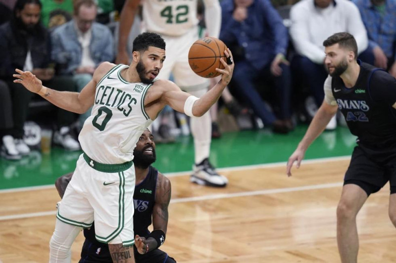 El alero de los Celtics Jayson Tatum y el base de Dallas Kyrie Irving pelean por el balón frente a Maxi Kleber de los Mavericks en el juego 1 de las Finales de la NBA.