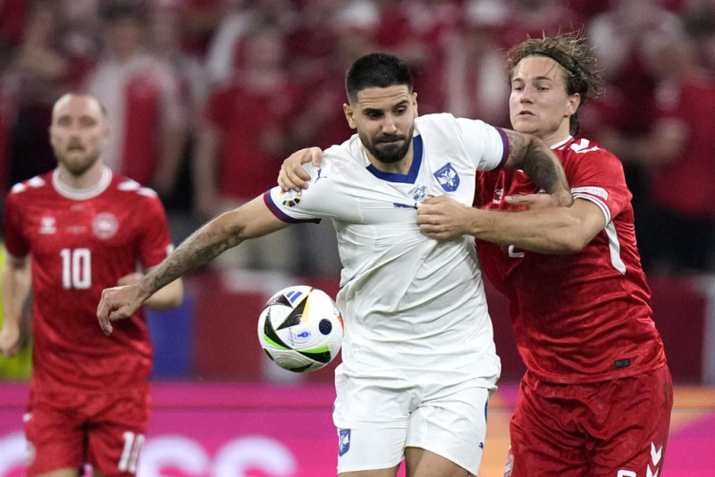 El serbio Aleksandar Mitrovic, centro, lucha por el balón contra el danés Joachim Andersen, a la derecha, durante un partido del Grupo C entre Dinamarca y Serbia en la Eurocopa 2024