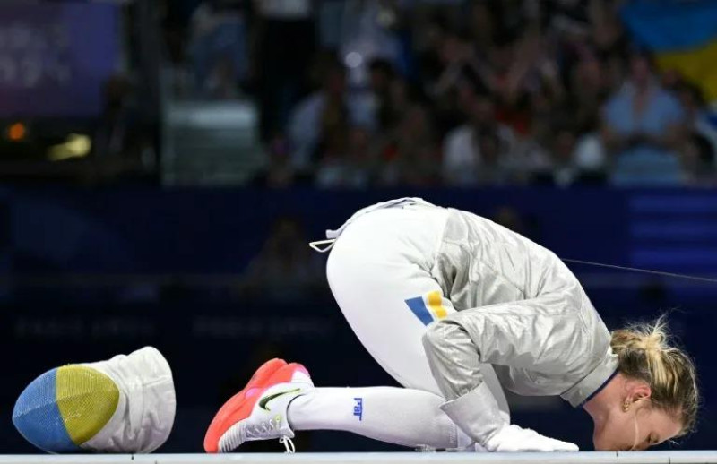 La esgrimista ucraniana Olga Kharlan besa el suelo para celebrar la medalla de bronce en sable individual en los Juegos Olimpicos de París.