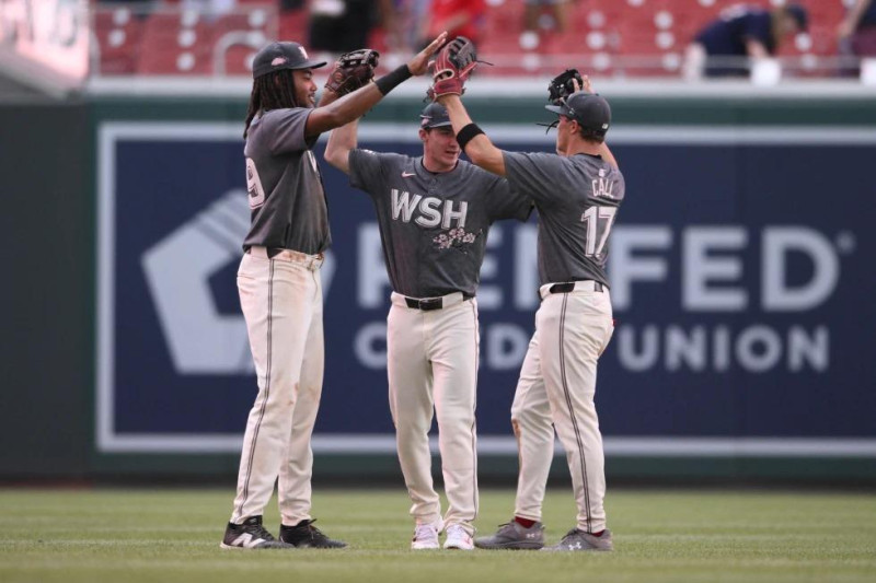 De izquierda a derecha, James Wood, Jacob Young y Alex Call, de los Nacionales de Washington, celebran después de un partido contra los Cerveceros de Milwaukee.