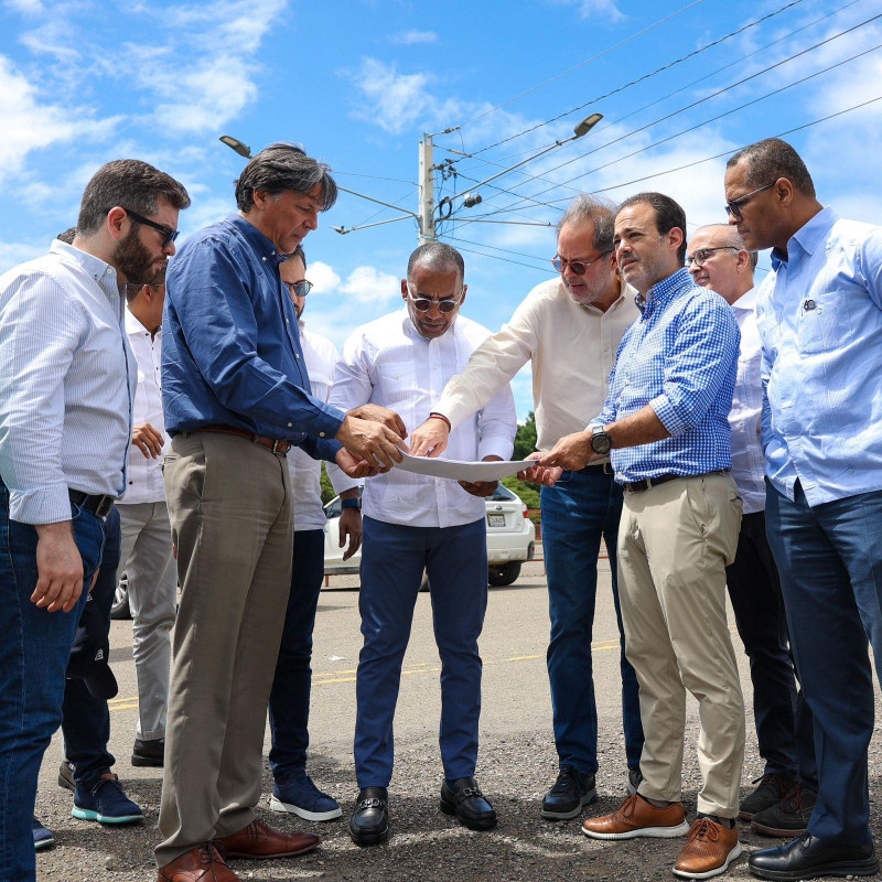 Funcionario y empresarios de Santiago observan los planos del helipuerto.