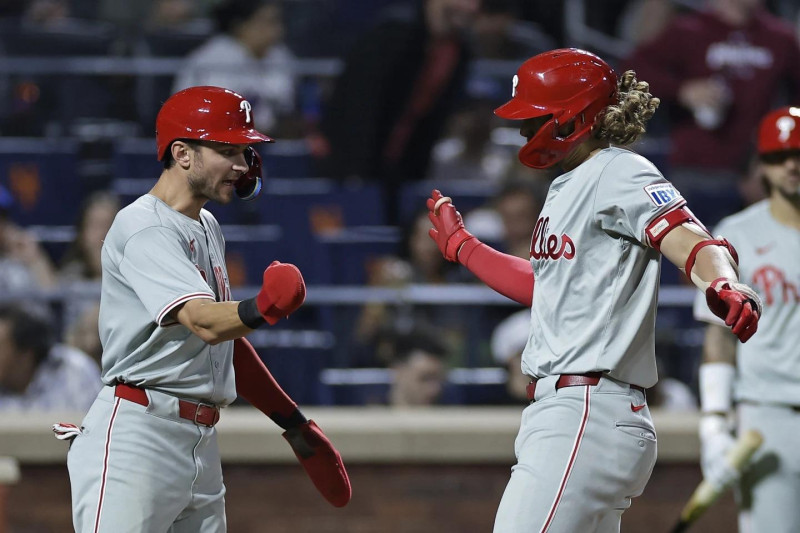 Alec Bohm, de los Filis de Filadelfia, es felicitado por Trea Turner, a la izquierda, después de conectar un jonrón de tres carreras durante la cuarta entrada de un partido de béisbol contra los Mets de Nueva York.