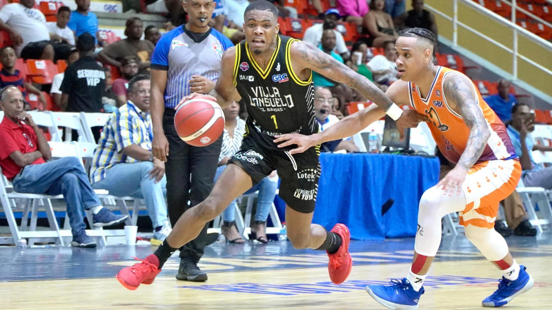 Brayan Ramírez, del Rafael Barias, maneja el balón ante la defensa de Randy Bautista, de Huellas del Siglo.