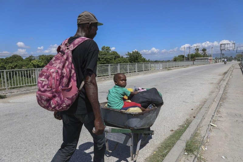 Un hombre empuja a un niño en una carretilla en Pont-Sonde, Haití, el 7 de octubre del 2024, días después de una matanza en esa área.