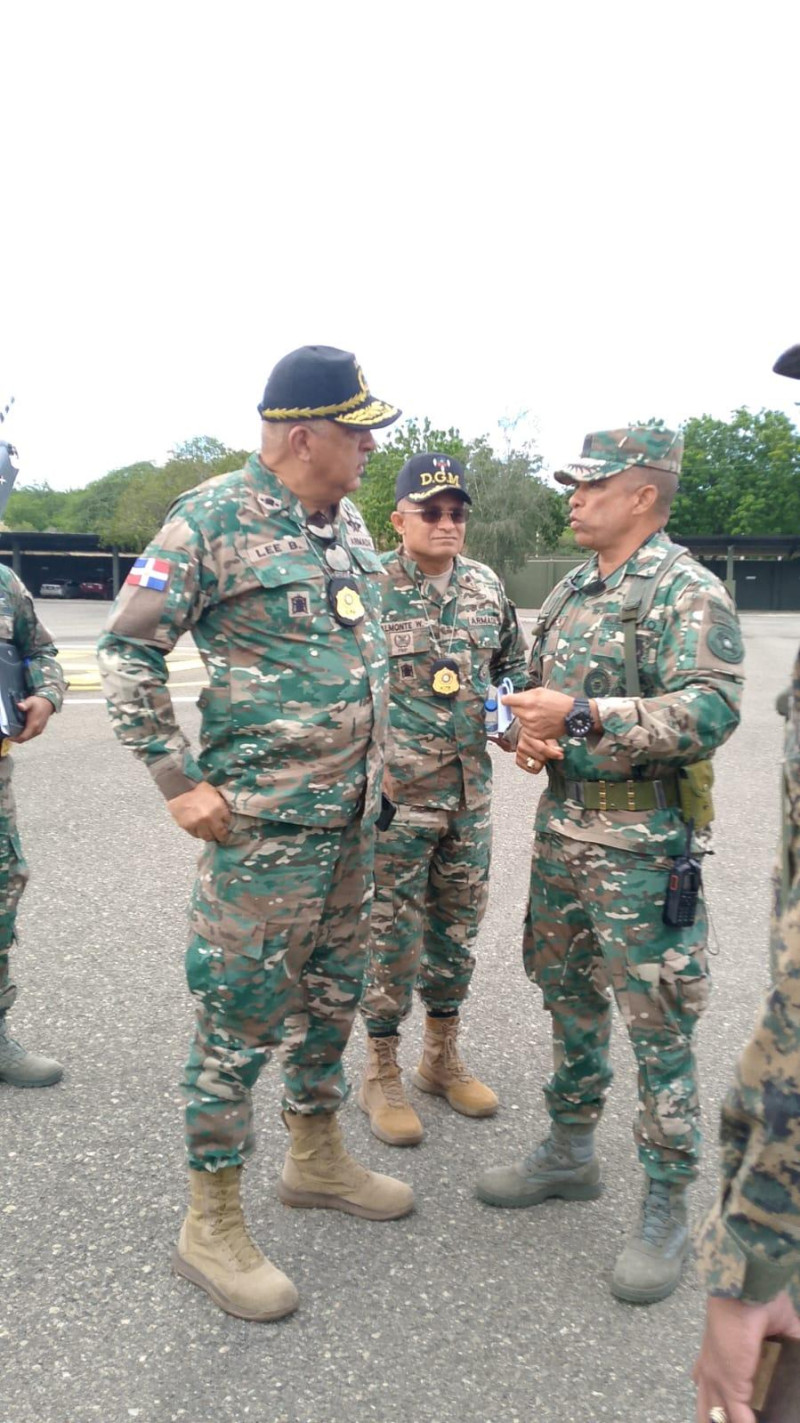 Vicealmirante Luis Rafael Lee Ballester (izq.),  director de Migración, hablan ayer con oficiales del Ejército, en Mao.