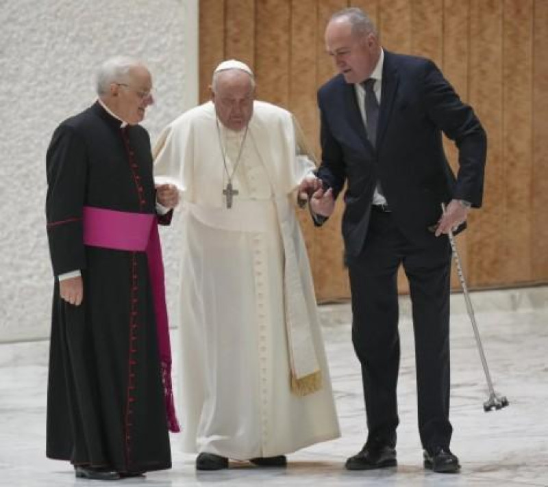 El Papá Francisco auxiliado por sus ayudantes tras romperse su bastón.