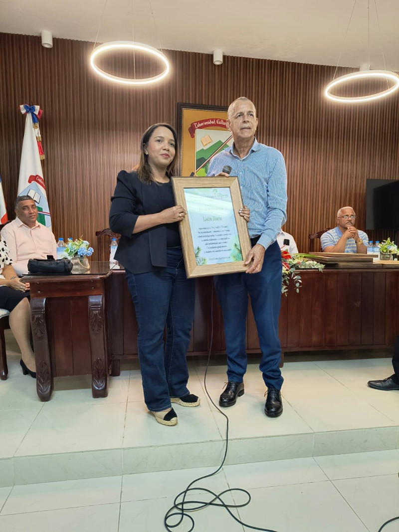 Indira Vásquez, de Listín Diario, recibe el certificado de reconocimiento.