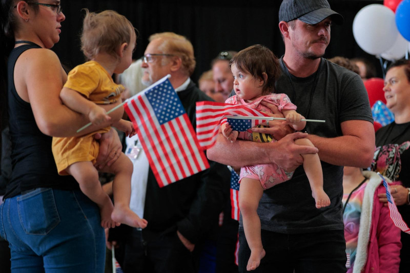 El primer grupo de afrikáners en llegar para reasentamiento escucha las declaraciones de funcionarios estadounidenses en el Aeropuerto Washington, Dulles, ayer.