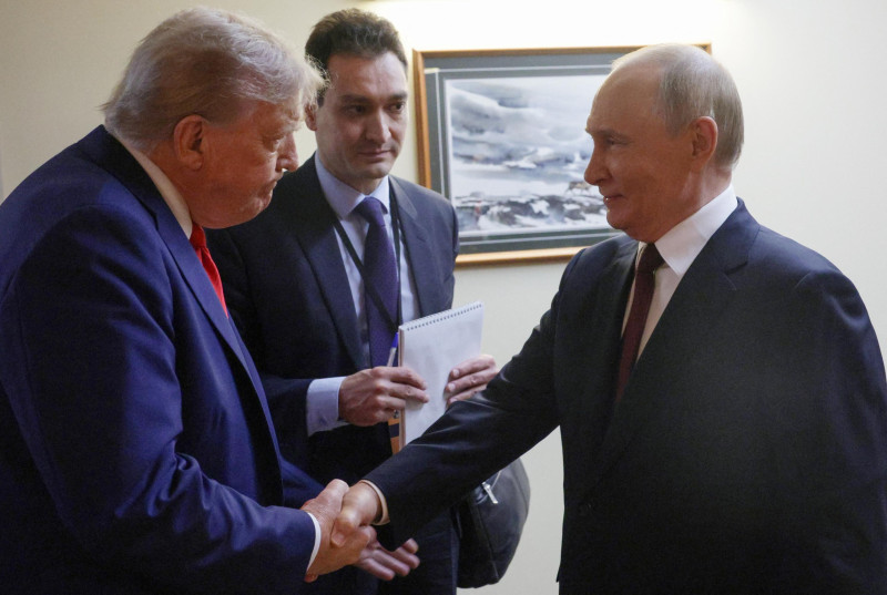 En esta foto compartida por la agencia estatal rusa Sputnik, el presidente estadounidense Donald Trump (izq.) y el presidente ruso Vladimir Putin (der.) se dan la mano antes de ofrecer una conferencia de prensa conjunta tras la cumbre entre Estados Unidos y Rusia sobre Ucrania en la base conjunta Elmendorf-Richardson en Anchorage, Alaska, el 15 de agosto de 2025. (Foto: Gavriil GRIGOROV / POOL / AFP)