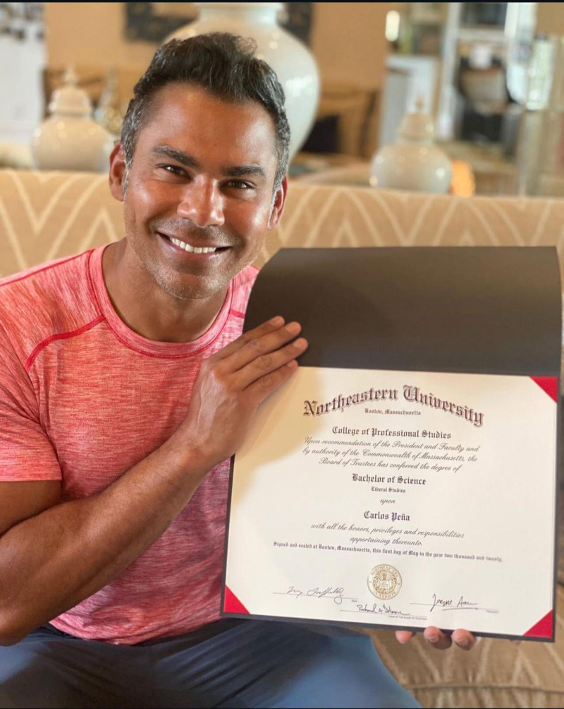 Carlos Peña, gerente de los Leones del Escogido, posa con su título de la Northeastern University.