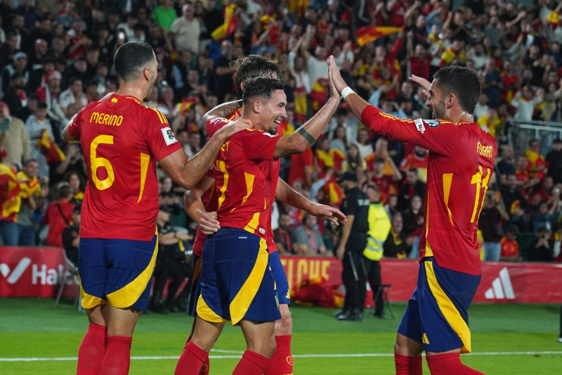 El español Yeremy Pino (centro) es felicitado tras anotar el primer gol de su equipo durante el partido de clasificación para el Mundial 2026 entre España y Georgia en el estadio Manuel Martínez Valero de Elche, España, el sábado 11 de octubre de 2025. (Foto AP/Alberto Saiz)