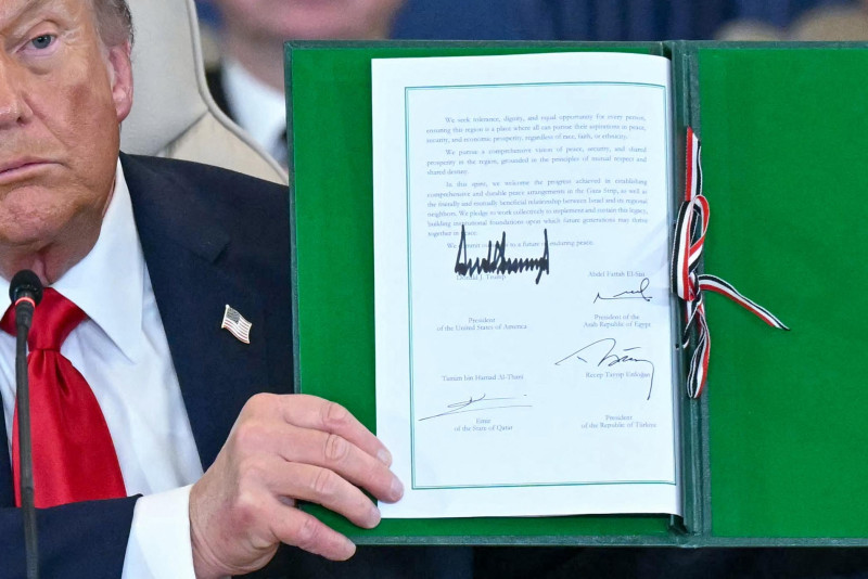 El presidente de Estados Unidos, Donald Trump, muestra un documento firmado durante una cumbre sobre Gaza en Sharm el-Sheikh el 13 de octubre de 2025.