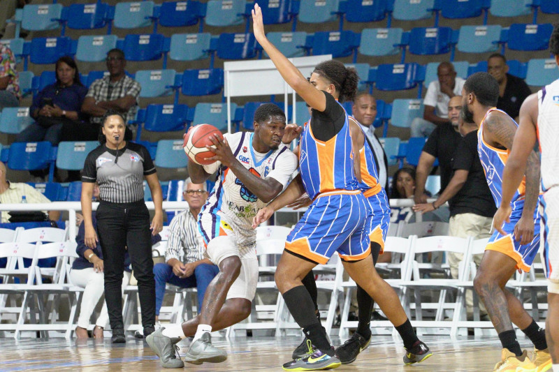 BJ Fiztgerald, del club Los Prados, en una acción ofensiva ante la defensa de Miguel Miranda, de Huellas del Siglo.