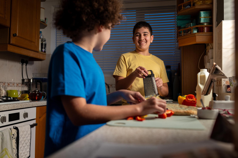 Adolescente con autismo haciendo pizza junto a su amigo