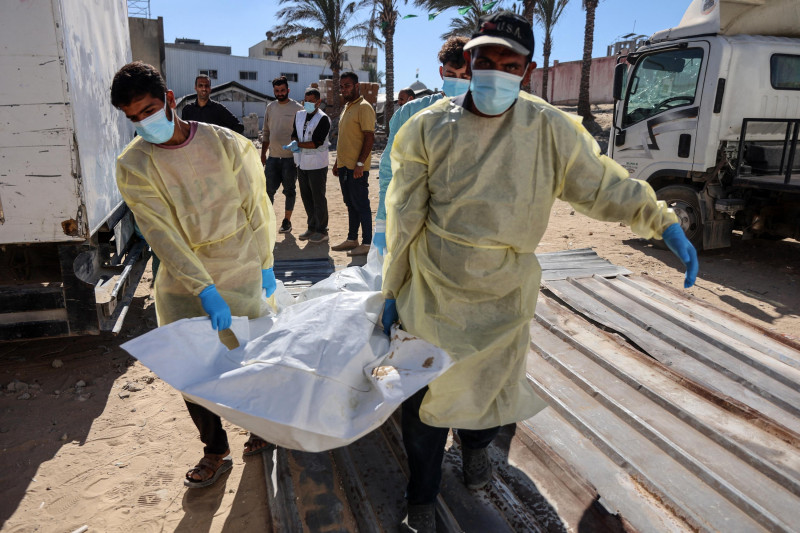 Trabajadores transportan los restos mortales de un palestino liberado por Israel tras acuerdo de alto el fuego e intercambio de rehenes en Gaza