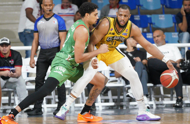 Jonathan Araujo, del club Rafael Barias, intenta usar su corpulencia ante la defensa de Fausto Pichardo, de Bameso.