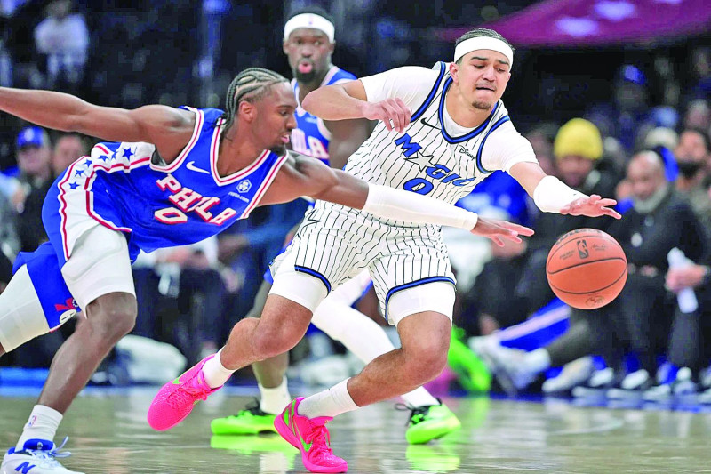 Anthony Black, de Orlando, y Tyrese Maxey, de los Sixers, van tras una bola perdida en el partido de la NBA, el 27 de octubre de 2025.