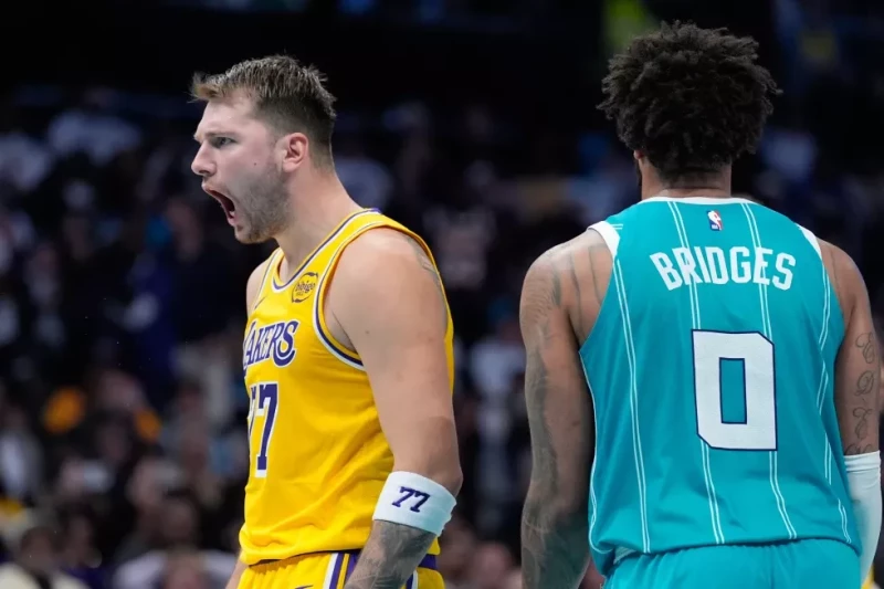 Luka Doncic, de los Lakers, celebra tras encestar mientras Miles Bridges, de Charlotte, observa durante la segunda mitad del juego de la NBA, el 10 de noviembre de 2025.