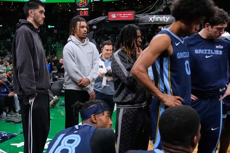 Ja Morant, base de los Grizzlies, segundo desde la izquierda, quien está marginado por una lesión, observa en un juego contra los Celtics de Boston.