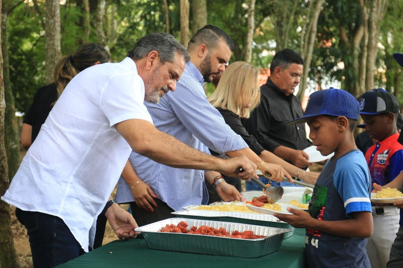 -El Comisionado de Béisbol Junior Noboa, sirve alimentos a los atletas de la Academia Montaño, da La Puya.