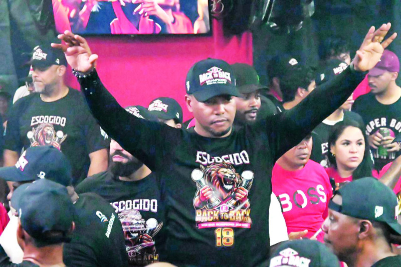 Ramón Santiago levanta los brazos en señal de victoria y haber materializado la conquista de la corona 18 por parte del Escogido