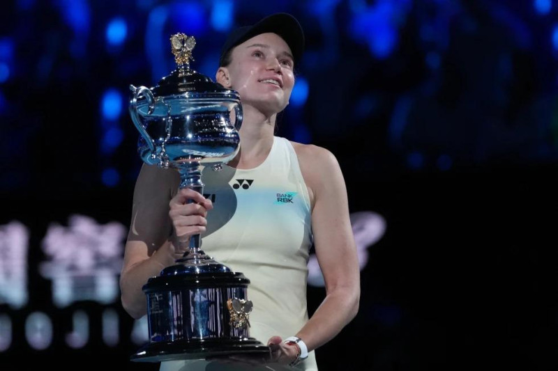 Elena Rybakina carga el trofeo del grand slam luego de vencer a Aryna Sabalenka en la final femenil del Abierto de Australia.