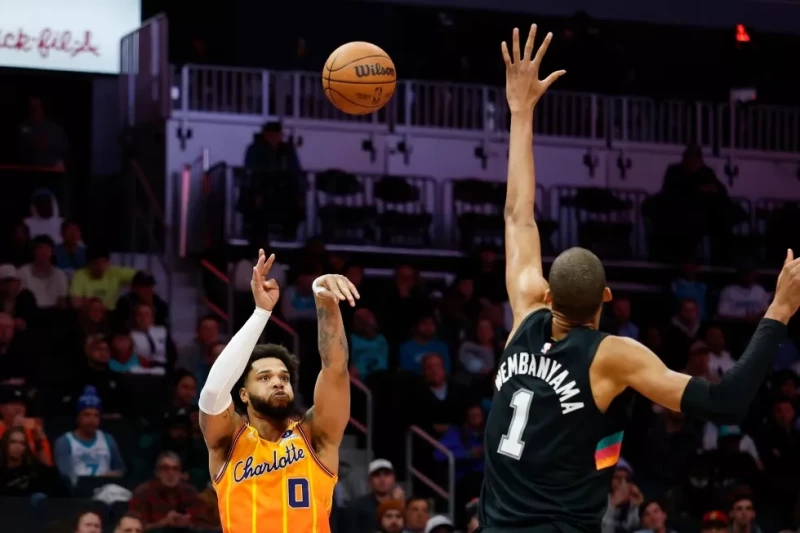 Miles Bridges, de los Hornets, lanza sobre Victor Wembanyama, de los Spurs, durante la segunda mitad del juego de la NBA, el 31 de enero de 2026, en Charlotte.