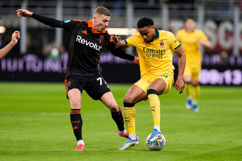 Ignace Van Der Brempt, izquierda, del Como, disputa el balón con Christopher Nkunku, del AC Milan, durante el partido de fútbol de la Serie A, el miércoles 18 de febrero de 2026, en Milán, Italia