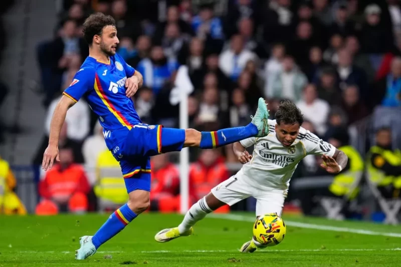 Rodrygo, a la derecha, del Real Madrid pugna por el balón con Sebastián Boselli, de Getafe, en el partido de la Liga española, el 2 de marzo de 2026.