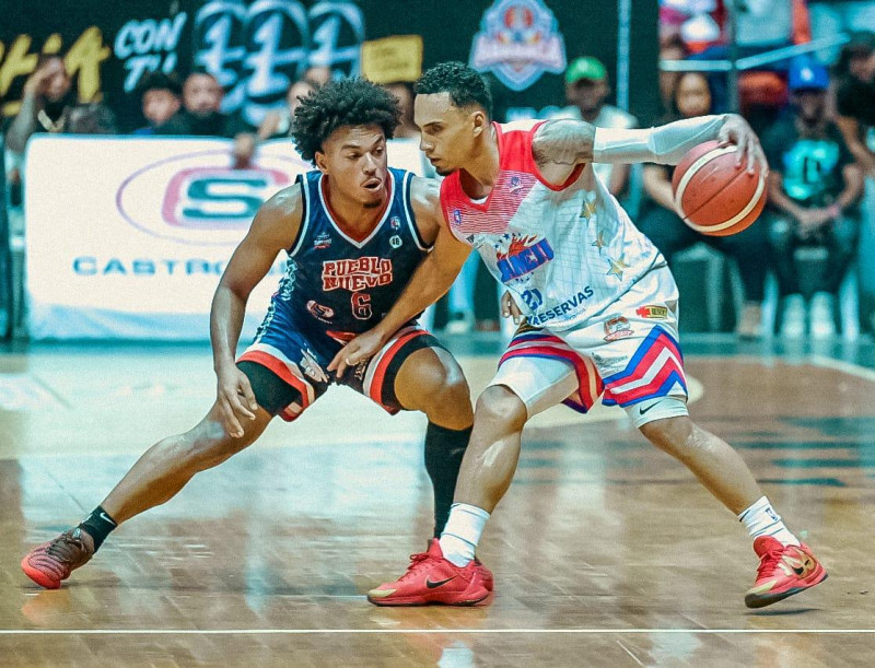 Alex Abreu, del Sameji, maneja el balón ante la defensa de Alberson Pimentel, de Pueblo Nuevo, en el primer partido de la final del torneo de baloncesto superior de Santiago.