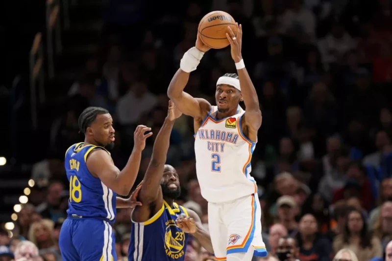 Shai Gilgeous-Alexander, del Thunder, busca enviar un pase frente a Draymond Green, de los Warriors, el 7 de marzo de 2026.