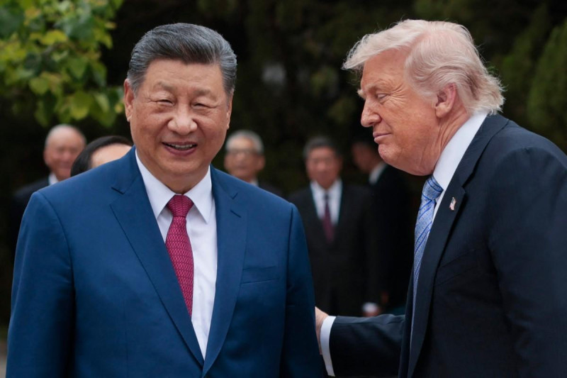 El presidente estadounidense Donald Trump (derecha) conversa con el presidente chino Xi Jinping al salir tras una visita al jardín Zhongnanhai en Pekín el 15 de mayo de 2026.