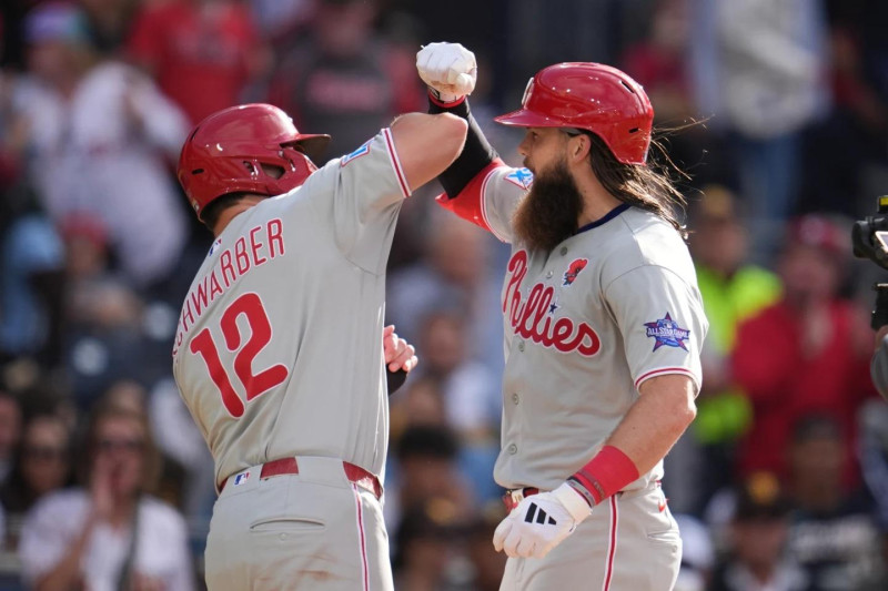 Kyle Schwarber e felicitado por su compañero Brandon March luego de conectar su jonrón 21 del año.