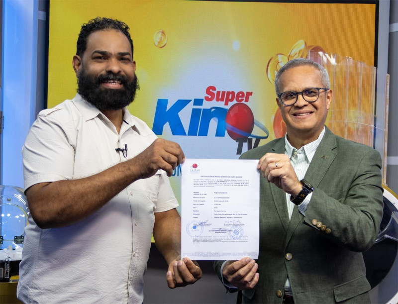 Genry Martínez Álvarez recibe el certificado de 25 millones de parte del director de sorteo de Leidsa, Manuel Abreu.