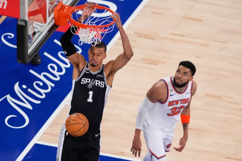 Victor Wembanyama, de los Spurs, ejecuta un donqueo ante la mirada de Karl-Anthony Towns en el tercer partido de la final de la NBA, el 8 de junio de 2026, en Nueva York.