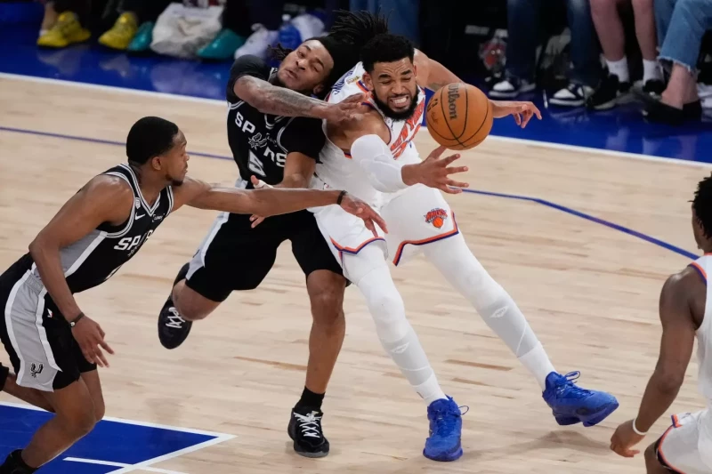 Karl-Anthony Towns, de los Knicks, y Stephon Castle, de los Spurs, se disputan el control del balón durante el cuarto partido de la final de la NBA, el 10 de junio de 2026.