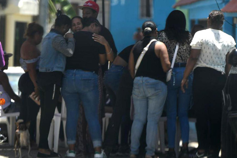 Familiares de uno de los jóvenes abatidos por la DIcrim el pasado sábado se consuelan, bajo llanto, durante el velatorio  en el  sector Los Frailes, de Santo Domingo Este.