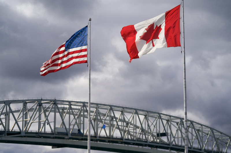 Las banderas de Estados Unidos y Canadá ondean junto al puente fronterizo Blue Water en Point Edward, Ontario, el 24 de octubre de 2025.