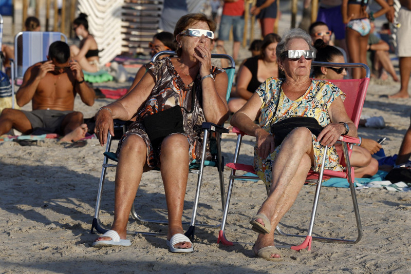 Dos mujeres observan el eclipse total de sol desde la playa del Arenal en Llucmajor, en la isla balear de Mallorca, el 12 de agosto de 2026.