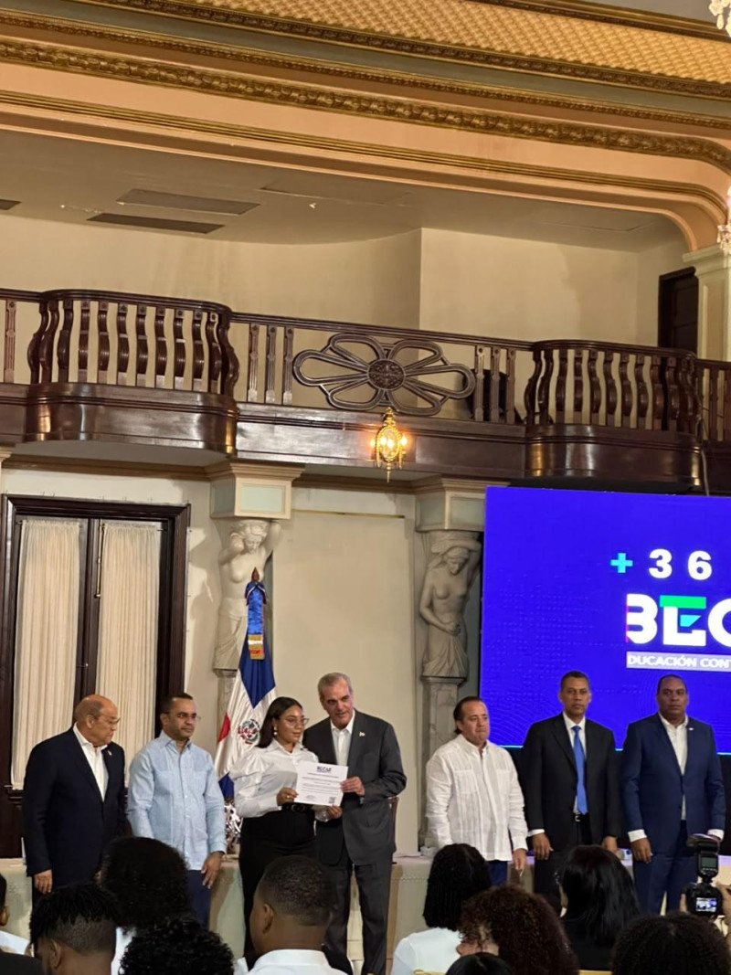 Una estudiante recibe su beca en el Palacio Nacional.