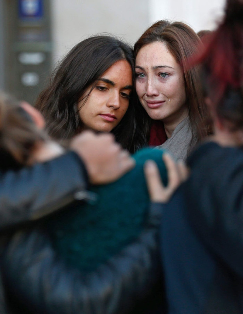 Jovenes lloran durante una vigilia cerca de la sala de conciertos Bataclan de París