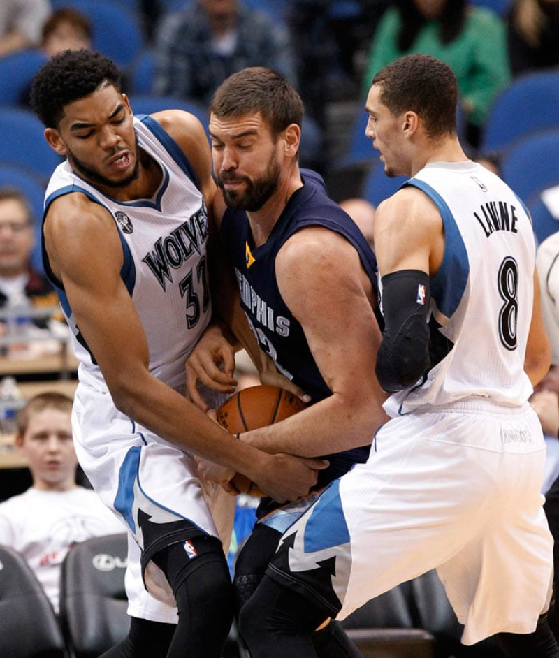 Lucha. Karl-Anthony Towns, de Minnesota, y Marc Gasol, de Memphis, luchan por una posesión en acción del encuentro de ayer en el baloncesto de la NBA.