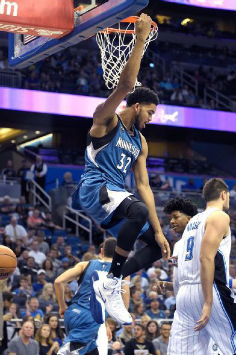 Karl-Anthony Towns, de Minnesota, se sostiene del aro luego de ejecutar un donqueo en el partido de ayer frente a los Magic de Orlando.