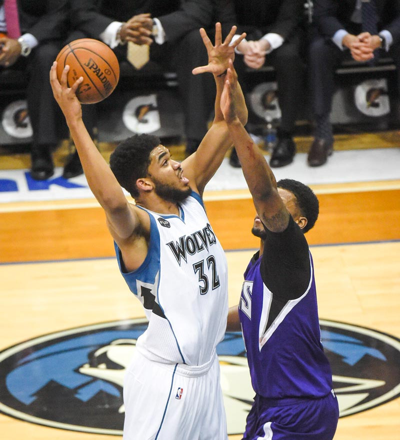 Karl-Anthony Towns, de Minnesosta, busca anotar un canasto sobre la defensa de Rudy Gay, de Sacramento durante el partido de anoche en el baloncesto de la NBA.