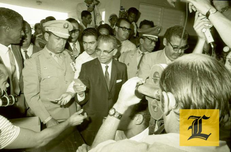 1970. Repartición pública.- Joaquín Balaguer,  quien aparece acompañado por Rafael Bello Andino, reparte dinero tras haber votado.