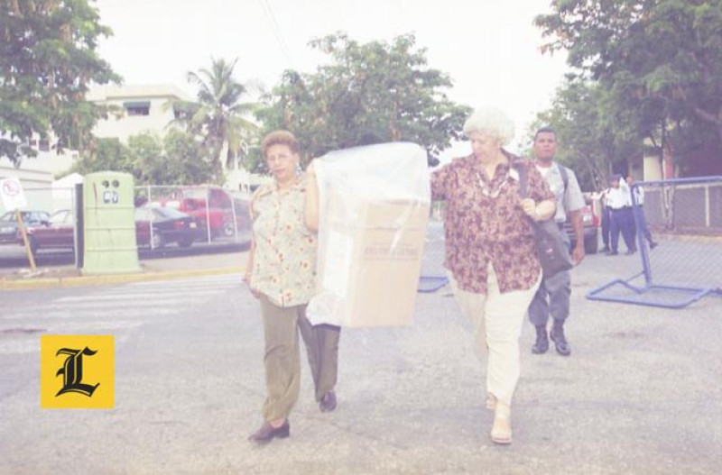 Mayo 2000. Mujeres. Otra urna es transportada dentro de una funda plástica por dos mujeres.