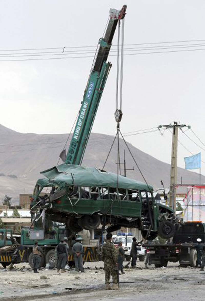 Miembros de seguridad afgana retiran un autobús destrozado tras un ataque suicida en las afueras de Kabul, Afganistán, en el que murieron unas 38 personas, en su mayoría cadetes de la Policía afgana. EFE/Hedayatullah Amid
