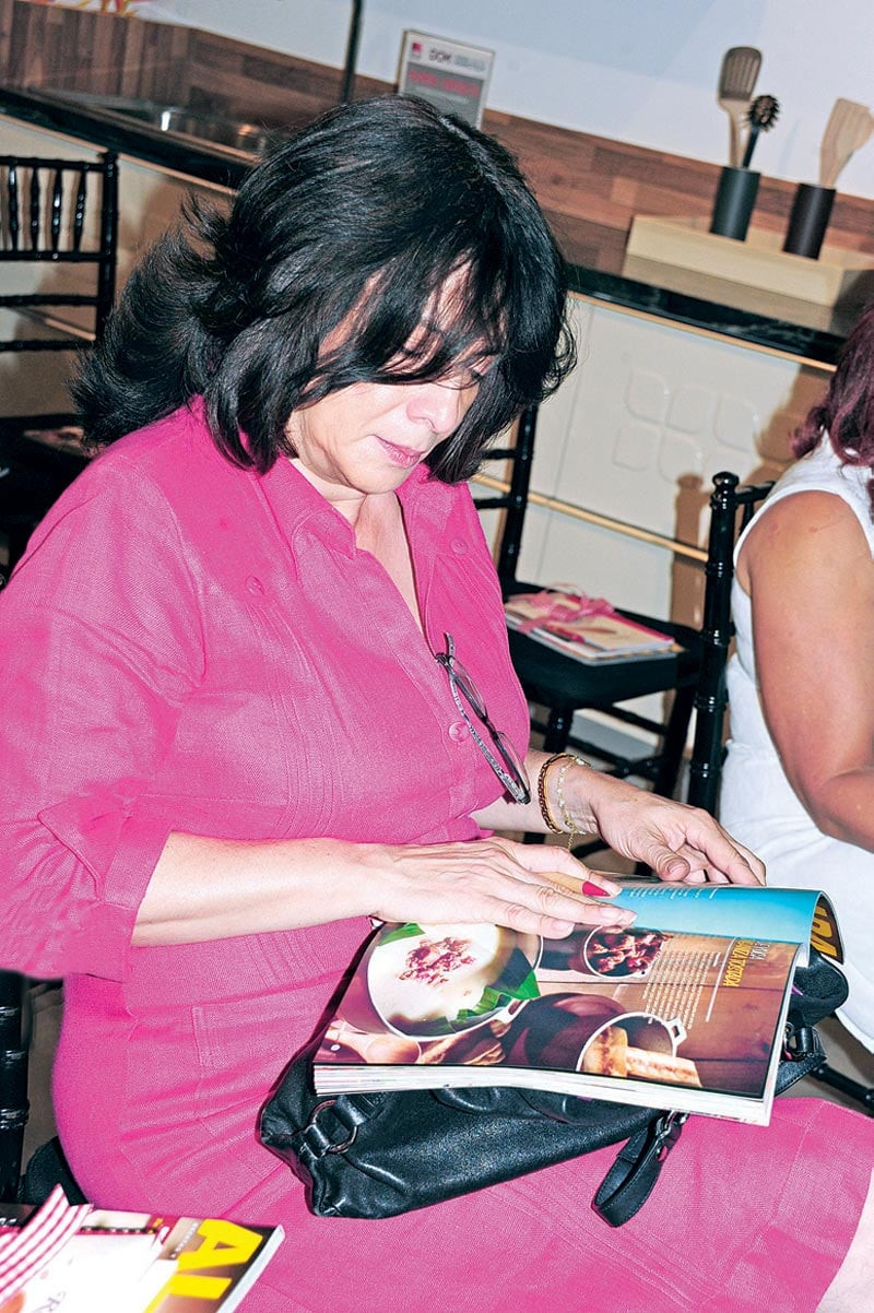 Yadira de Castro, observa el más reciente ejemplar de la revista Aldaba Gourmet.